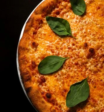 Angled view of Margherita pizza with basil leaves on tin at Sacred Slice Pizza Barcelona