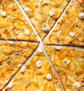 Sliced potato and ricotta pizza close-up showing golden crust at Sacred Slice Pizza Barcelona